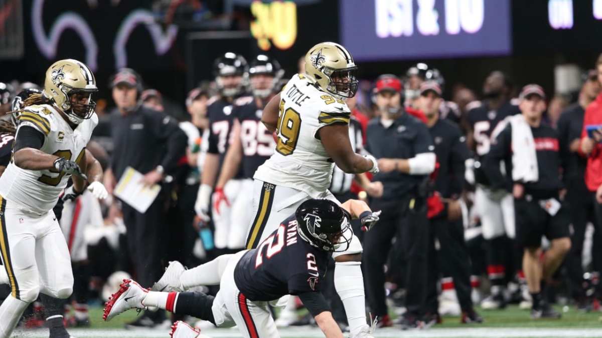 New Orleans Saints DT Shy Tuttle (99) stiff-arms Atlanta QB Matt Ryan (2) after an interception during a 2019 game between the teams. Credit: neworleanssaints.com